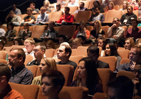 People sitting in a full theater room